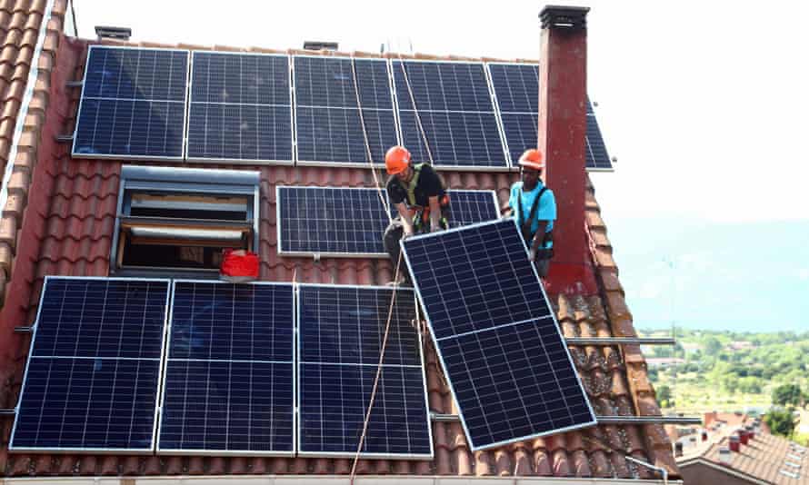 Workers install solar panels on the roof of a home in Colmenar Viejo, Spain.