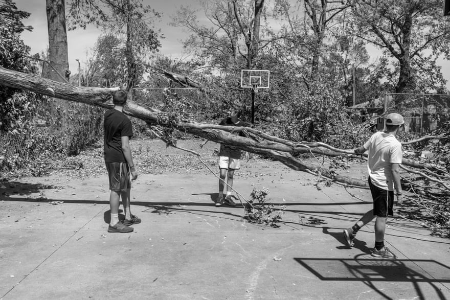 Kids remove storm debris from a park basketball court in Newhall, Iowa.