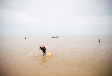 A man uses a net to catch fish in Tonlé Sap lake in Cambodia.