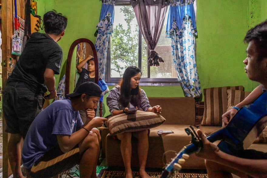 Donna’s children spending time together in their home in Tublay, Philippines. Two of them are looking at their phones