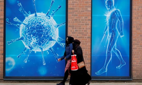 People walk past an illustration of a virus in Oldham.