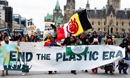 People march with a banner reading ‘End the Plastic Era’ in Ottawa, Canada