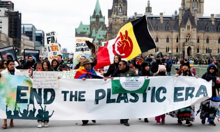 People march with a banner reading ‘End the Plastic Era’
