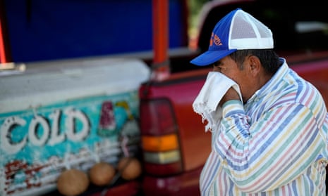 Andres Matamoros wipes the sweat from his face while selling fresh fruit and cold coconuts from his roadside stand Wednesday, June 28, 2023, in Houston.