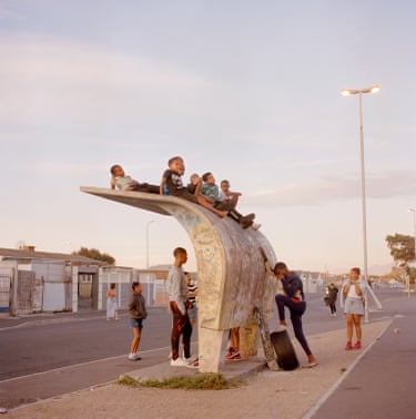 Laura Pannack, Bus Stop, The Journey HomePannack’s The Journey Home explores the daily walk to and from school in Cape Town’s gang-governed Cape Flats, where the threat of violence shapes ordinary childhood routines. Made collaboratively with young participants, the work offers an intimate portrait of adolescence, danger and resilience. Making our way home from school is a simple and widely shared ritual. Yet in South Africa, a country marked by deep social divides, this daily journey can carry very different realities, as young people navigate the daily threat of gang crossfire