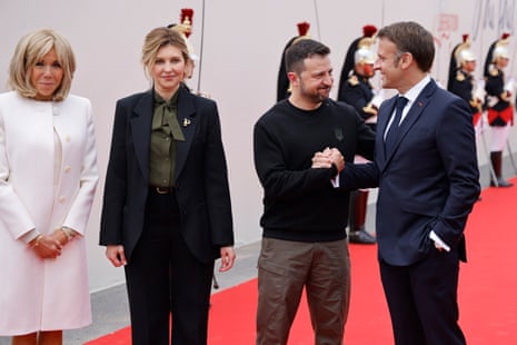 France's president Emmanuel Macron (R) greets Ukraine's president Volodymyr Zelenskiy and his wife, Olena Zelenska, upon their arrival at Omaha Beach.
