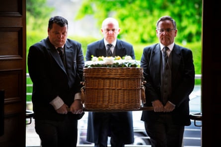 Greeted by a lone piper, Eddie’s wicker coffin arrives at the crematorium