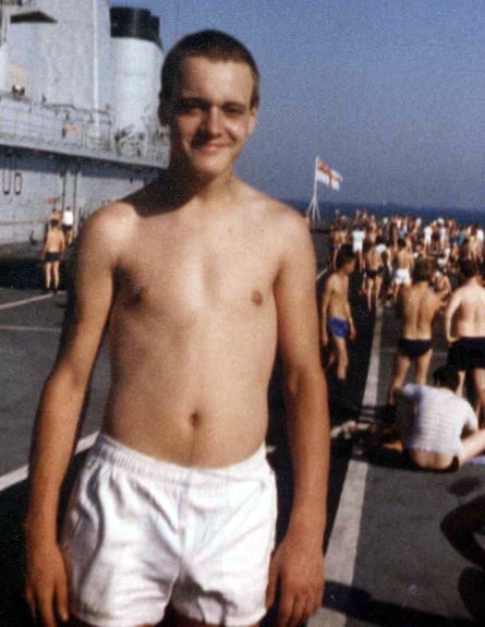 Simon Parkes wearing white shorts and naked from the waist up, while standing on the deck of a Royal Navy ship
