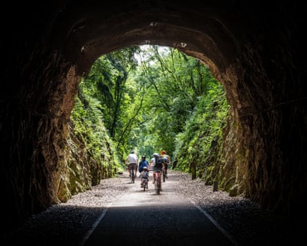 A family cycles on the Strawberry Line, part of the National Cycle Network route 26, at Shute Shelve Tunnel near Axbridge in Somerset.
