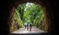 A family cycling out of a tunnel