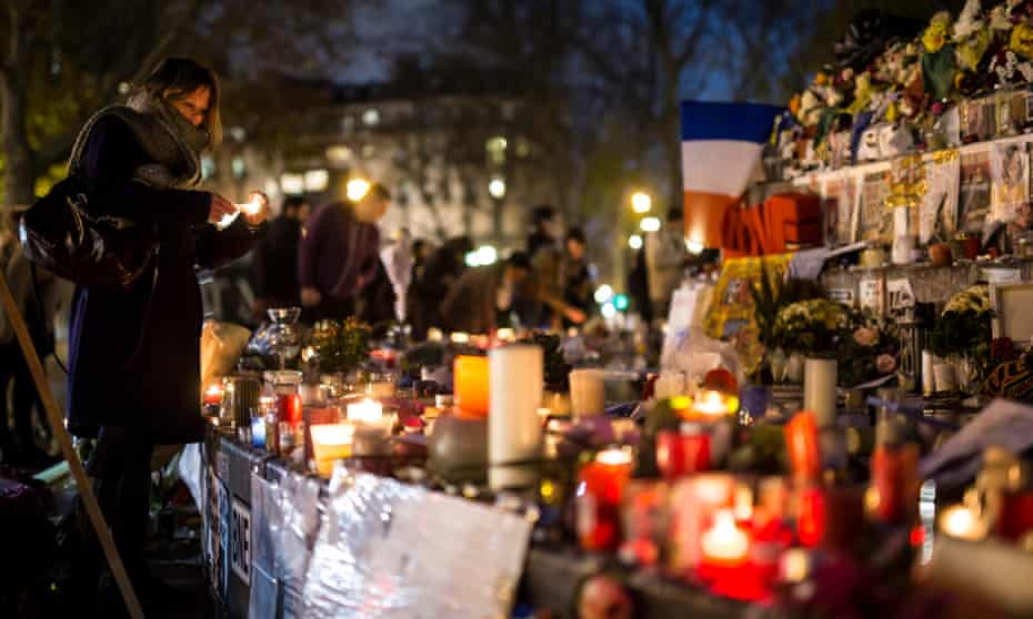 A woman lights a candle for the victims of the terrorist attacks at Place de la République, Paris. 