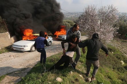 Palestinians help an injured young man during clashes with Israeli settlers in the village of Burin near Nablus city in the West Bank on 25 February.
