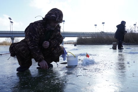Residents of Novoaidar, which is currently under the control of Russian forces, are seen ice fishing.