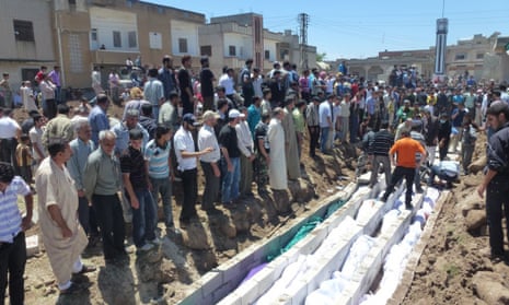 People in Syria watching the mass burial of victims of the Houla massacre in 2012