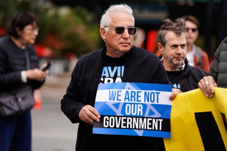 Ένας άνδρας κρατά μια πινακίδα που γράφει: «Δεν είμαστε η κυβέρνησή μας».