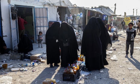 Women wearing burqas buying food  in Al Hawl camp, Syria