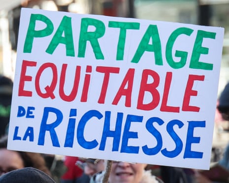 A protester holds a placard reading "fair distribution of wealth" during a rally in Valenciennes