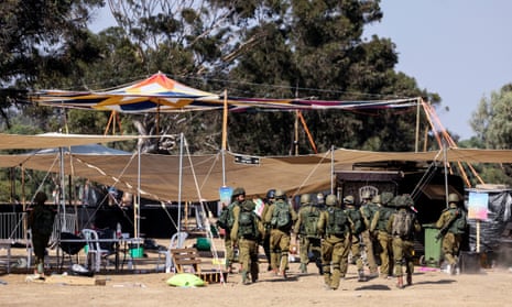 Israeli soldiers walk through the site of the Supernova festival in the days after the attack