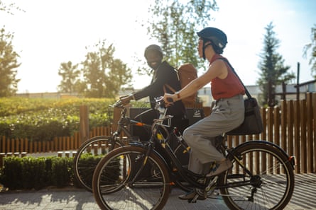 راكبان دراجتين يسيران على طول ممر ذو مناظر自然ة في يوم مشمس