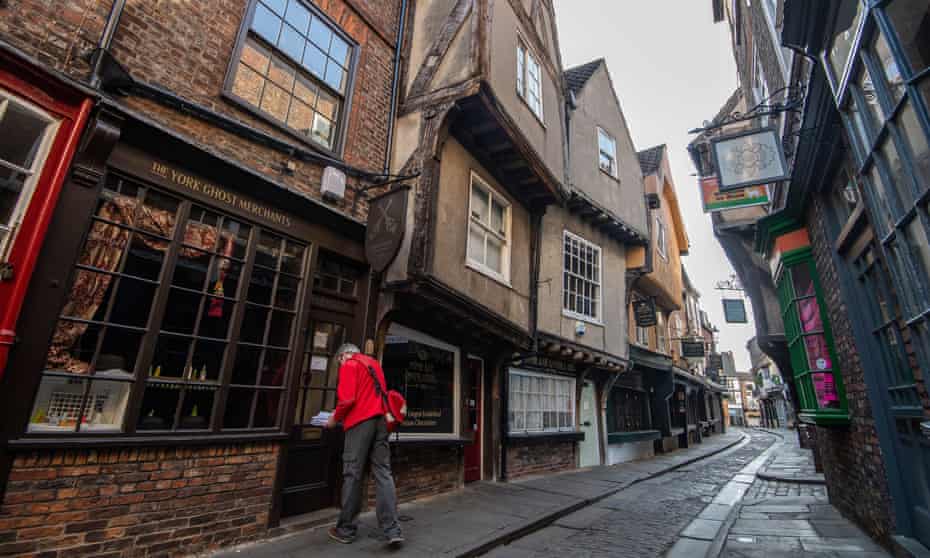 A postman delivers mail to shops in the Shambles in York