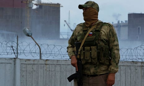 A Russian soldier stands guard near the Zaporizhzhia nuclear power plant