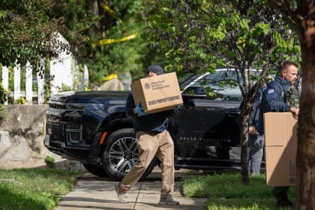 man carries box labeled 'homeland security investigations' on to sidewalk as other stand by with empty boxes