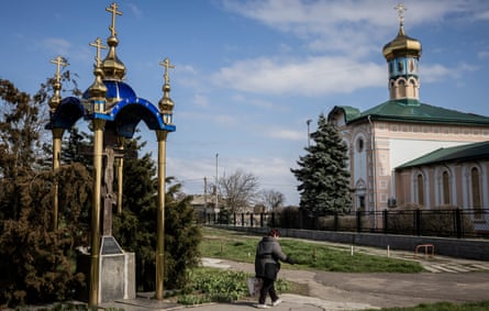 A woman walks pass a church in Ochakiv in southern Ukraine.