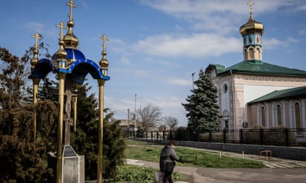 Une femme passe devant une église à Ochakiv, dans le sud de l'Ukraine.