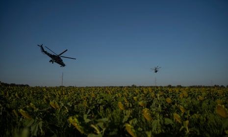 Ukrainian attack helicopters fly over a sunflower field in eastern Ukraine.