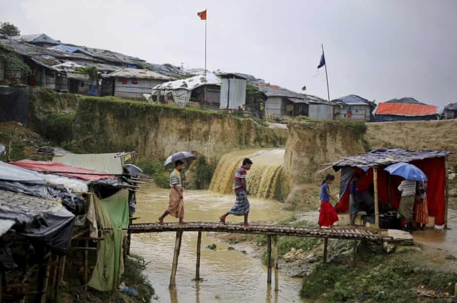 Rohingya refugees cross a makeshift bamboo bridge over the sewer in Kutupalong refugee camp, Bangladesh.