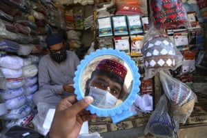 Peshawar, Pakistan. A man tries on a traditional cap in preparation for the Muslim fasting month of Ramadan