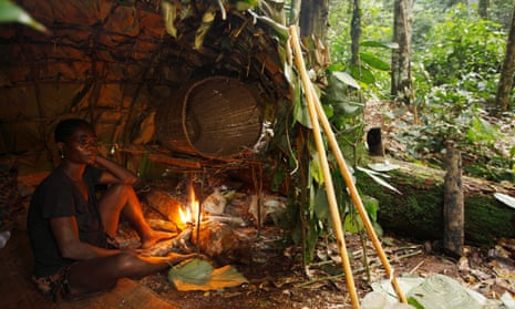 Baka man taking shelter in a Mongolu at a forest hunting camp, Cameroon