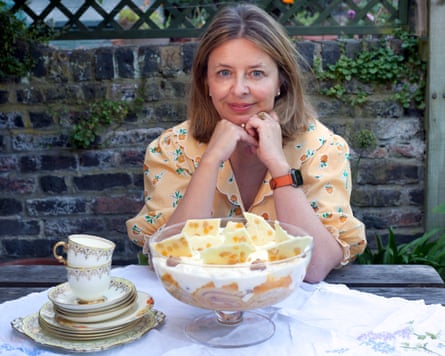 Rachel Cooke sitting at a garden table with a bowl of trifle
