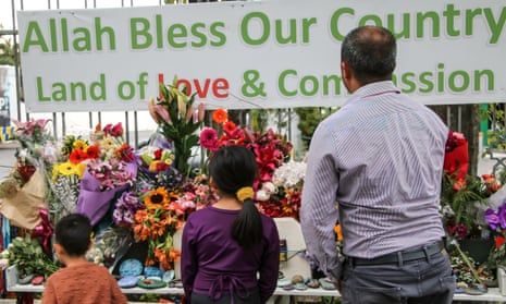 A man and his children place flowers as a tribute outside the Al-Noor Mosque in christchurch