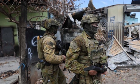 Australian soldiers patrol a burned-out area of Honiara’s Chinatown, in Solomon Islands