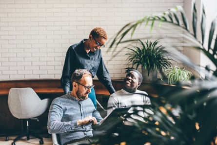 Multi-ethnic coworkers discussing in office.