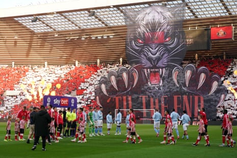 Sunderland and Coventry City players walk onto the field as a large banner is displayed