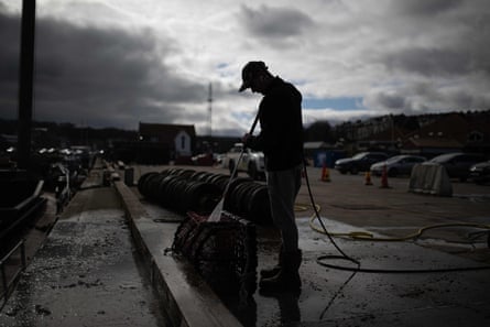 Deckhand Ben Hinchley cleans lobster pots
