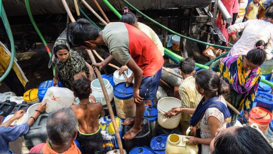 People fill water containers from a tanker in the New Delhi slums.