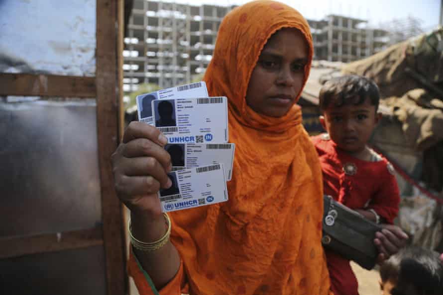 A Rohingya woman displays her family’s UNHCR identity cards at a makeshift camp on the outskirts of Jammu, India.