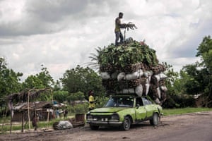 Vegetables, wood and charcoal are loaded onto the roof of a battered Peugeot in Matadi, Democratic Republic of the Congo.