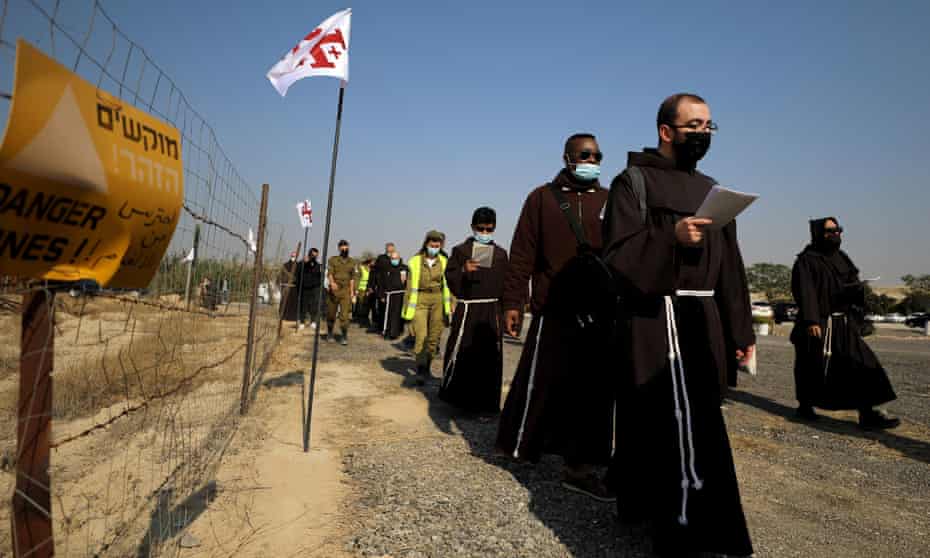 Pilgrims march towards the Jordan River to participate in a baptism ceremony at the Qasr el-Yahud site, near Jericho