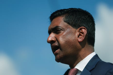 A man in a suit under a blue sky.