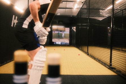 A batter standing in the nets looking at the simulator