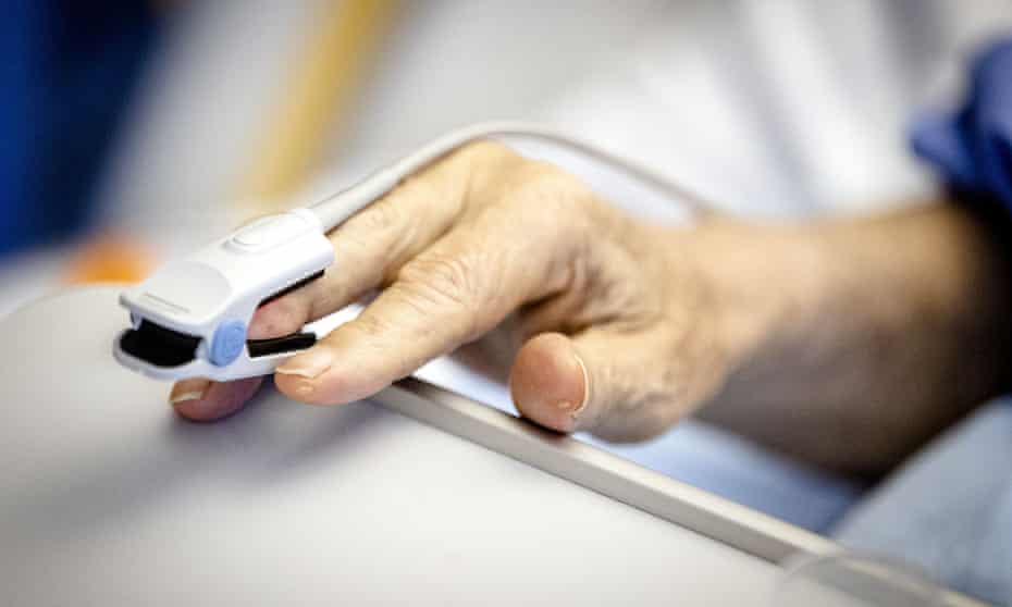 Stock photo of a pulse oximeter with a Covid patient