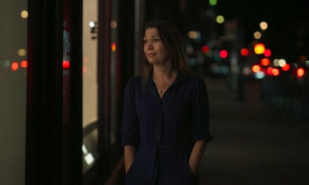 A woman, hands in her pockets, looks wistfully out a window at night in a still from the BBC documentary Al Fayed: Predator at Harrods