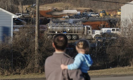 A family inspects the wreckage of the train derailment in East Palestine, Ohio, on 19 February. 