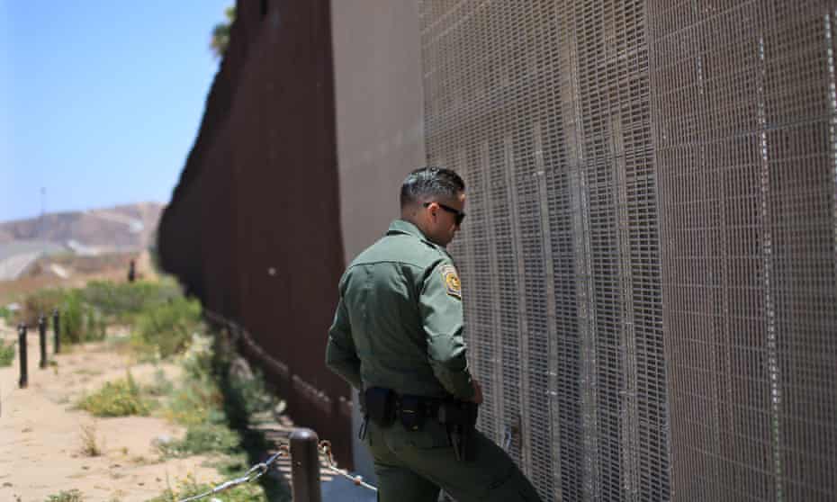 An agent patrols the US-Mexico border wall in California. 
