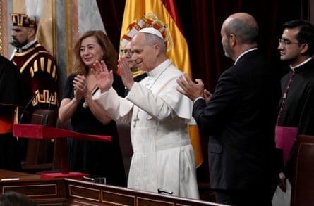 The pope raises his hands as people applaud