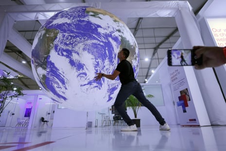 An attendee poses for a picture near a model earth.